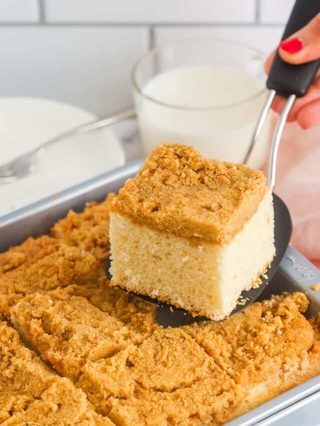 a spatula picking up a slice of bisquick coffee cake from the pan.