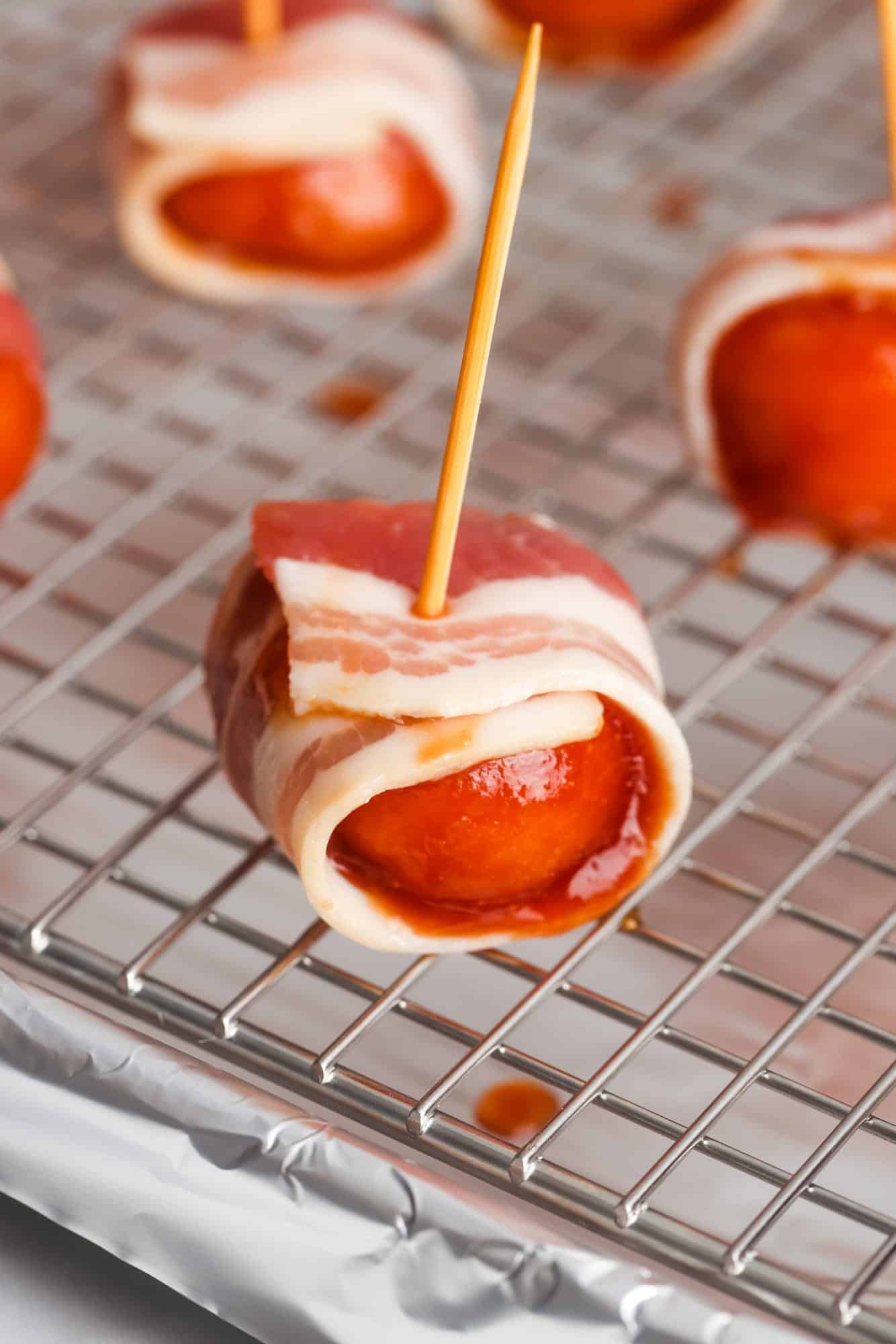 closeup of uncooked bacon wrapped water chestnut with a toothpick in it. 