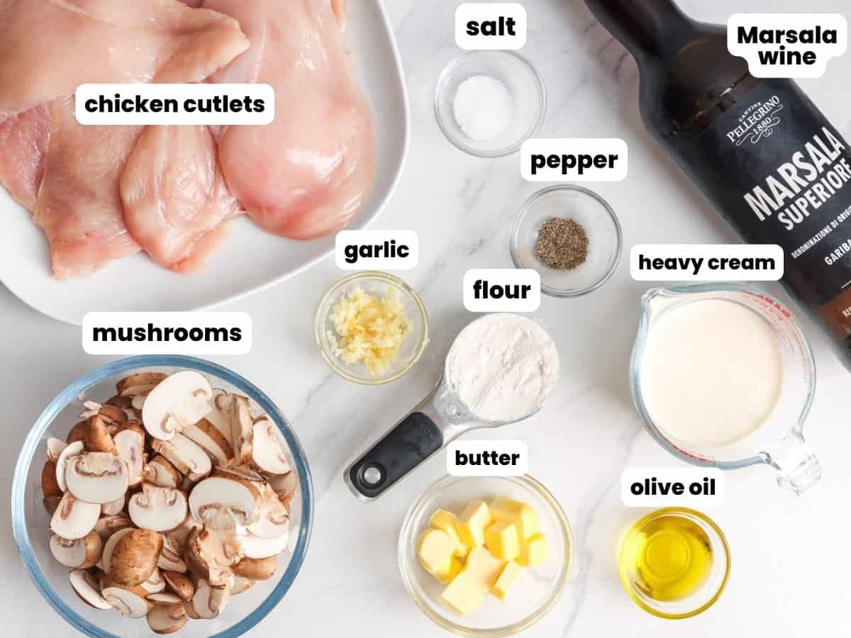 The ingredients needed to make chicken marsala, including wine, mushrooms, and chicken cutlets. 