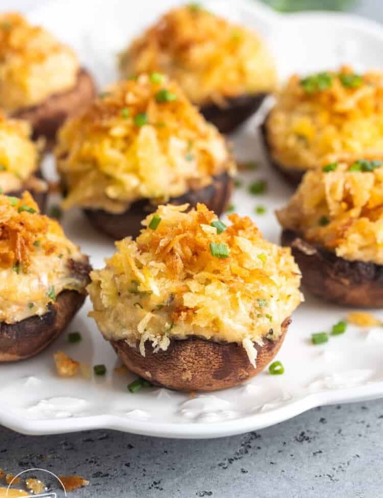 a white plate of crab stuffed mushrooms with browned filling.