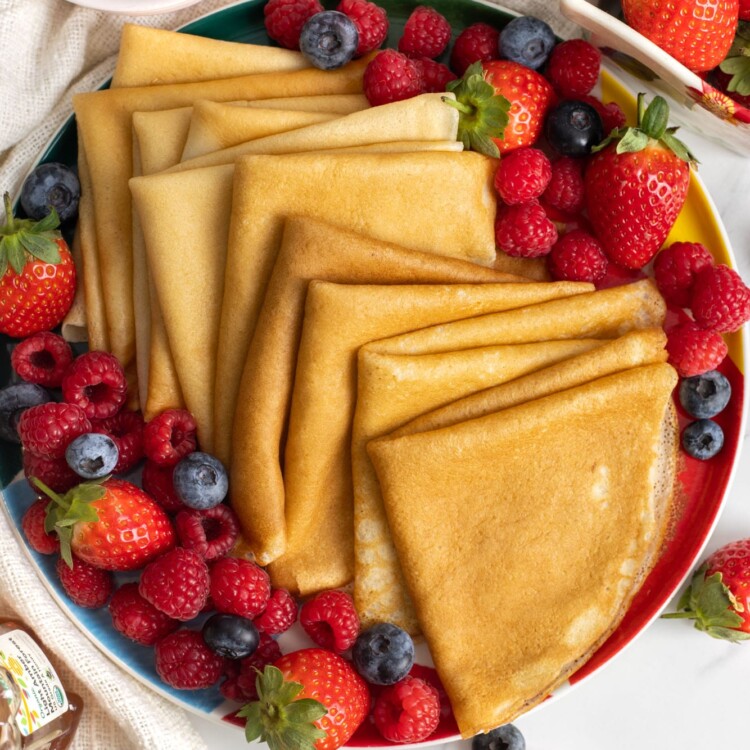 a plate holding folded crepes and fresh berries.