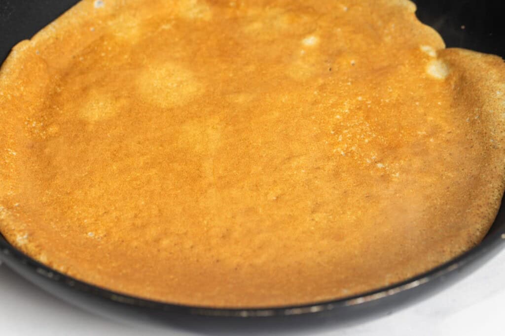 the golden brown color of a homemade crepe after flipping it.