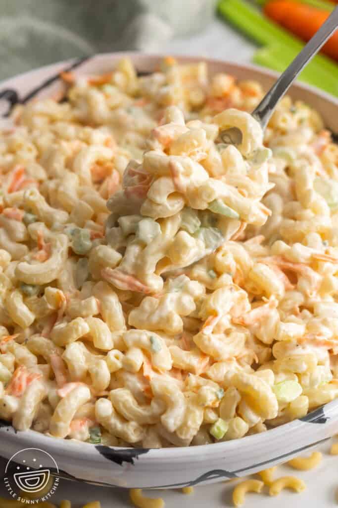 a bowl of hawaiian macaroni salad, served with a spoon.