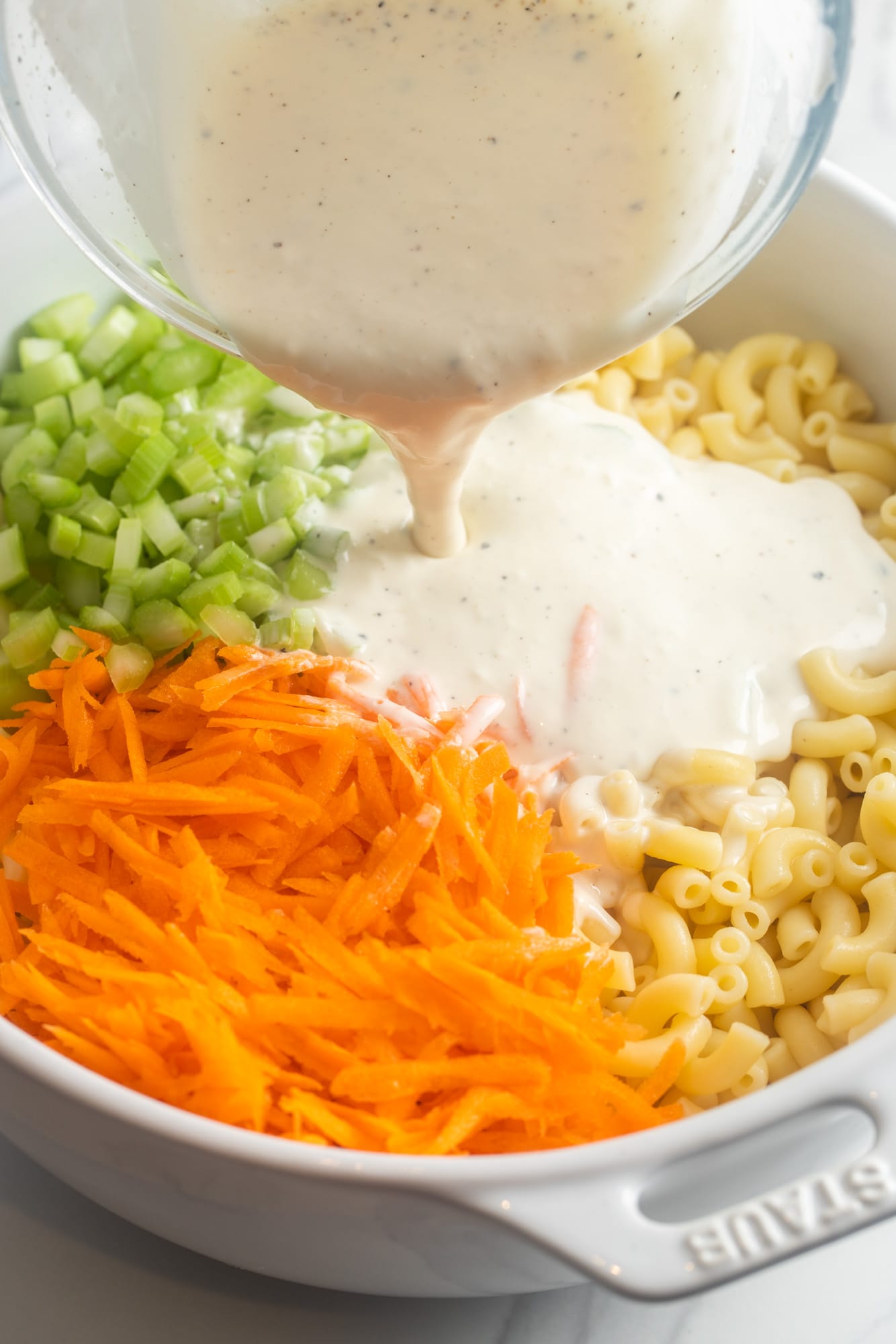 creamy mayo dressing poured over cooked pasta, diced celery and grated carrot.