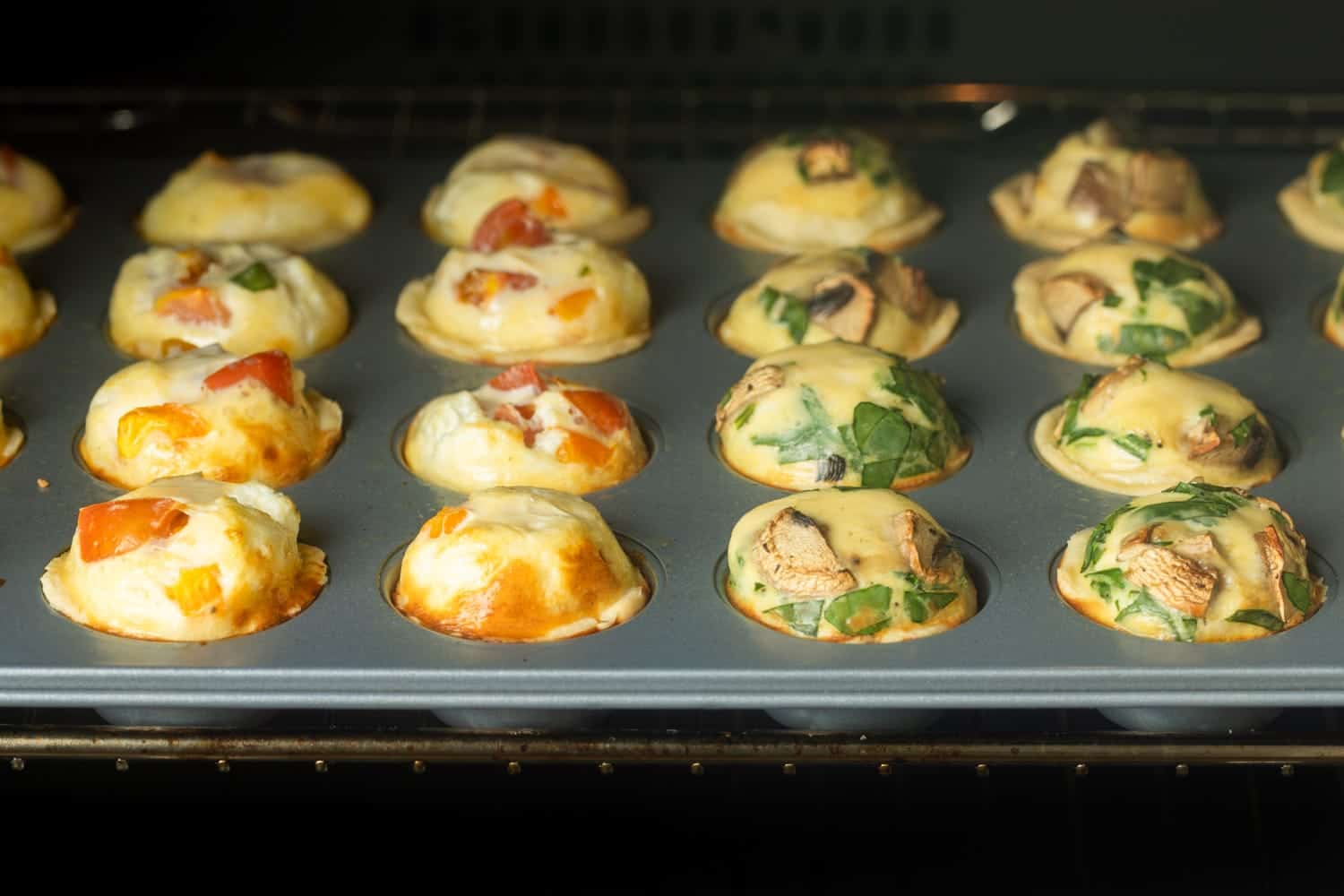 mini quiche baking in an oven. 