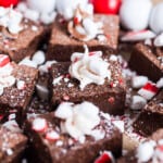 closeup of a platter of fudge with peppermint pieces and whipped vanilla frosting.