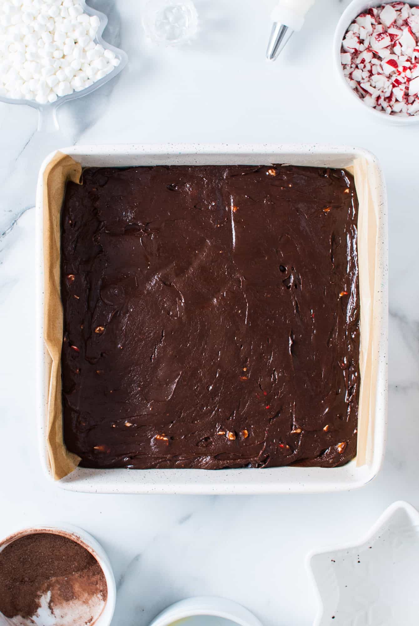 peppermint fudge pressed into a square baking pan that was lined with parchment paper
