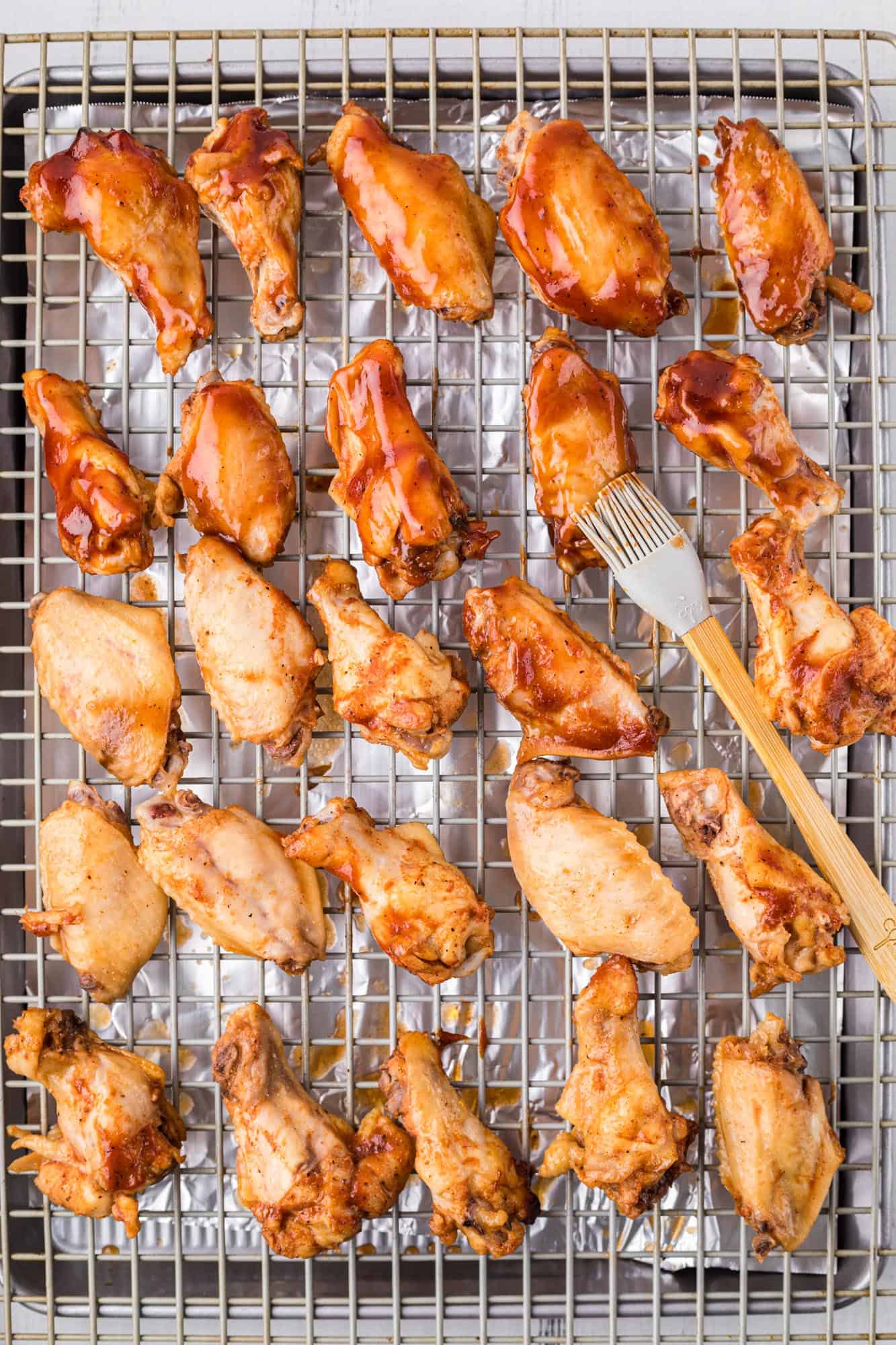 slow cooker wings placed on a rack and brushed with extra sauce. 