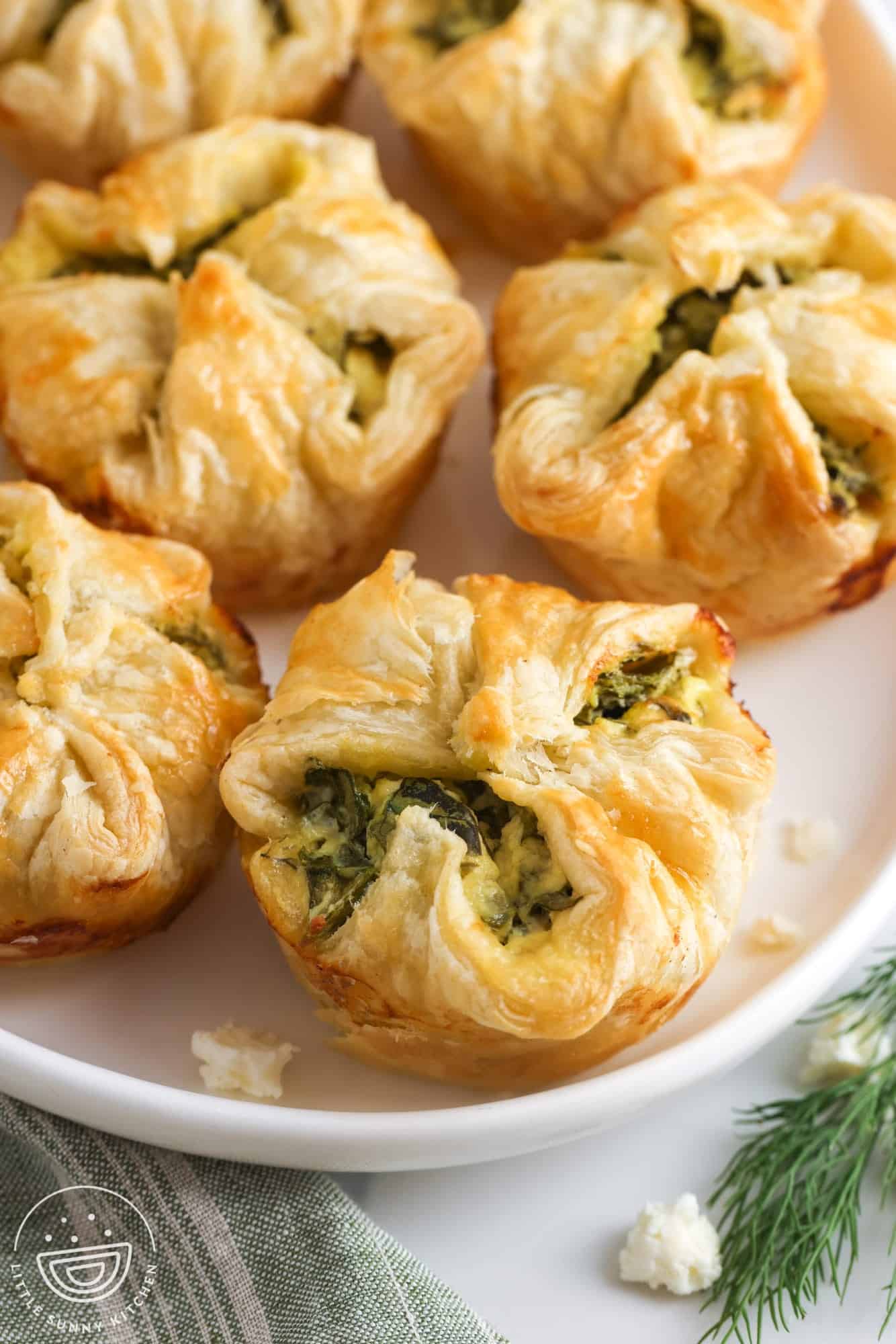spinach puff pastry appetizers in a white plate. 