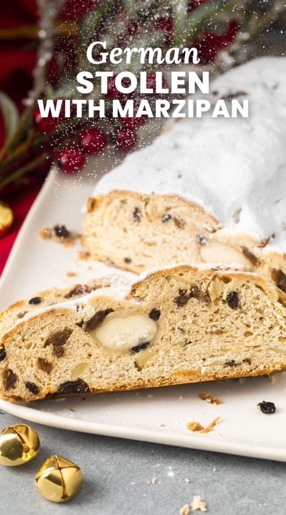 a loaf a stollen on a white plate. The bread is sliced, showing the inside filled with dried fruits and marzipan. Text overlay says "german stollen with marzipan"