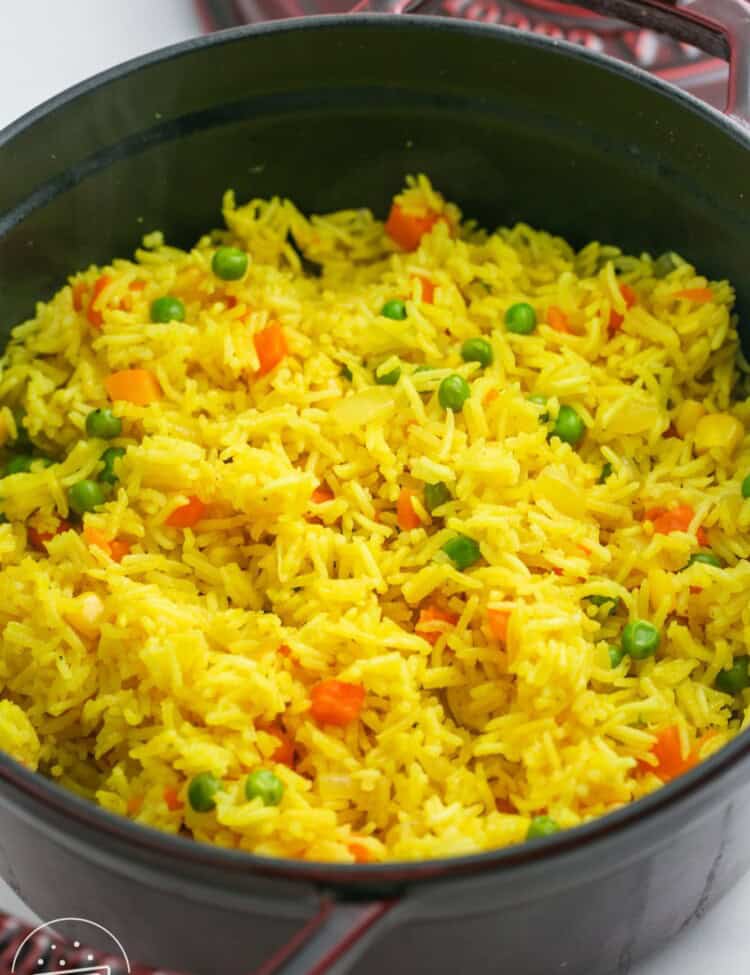 a large saucepan of yellow rice with vegetables.