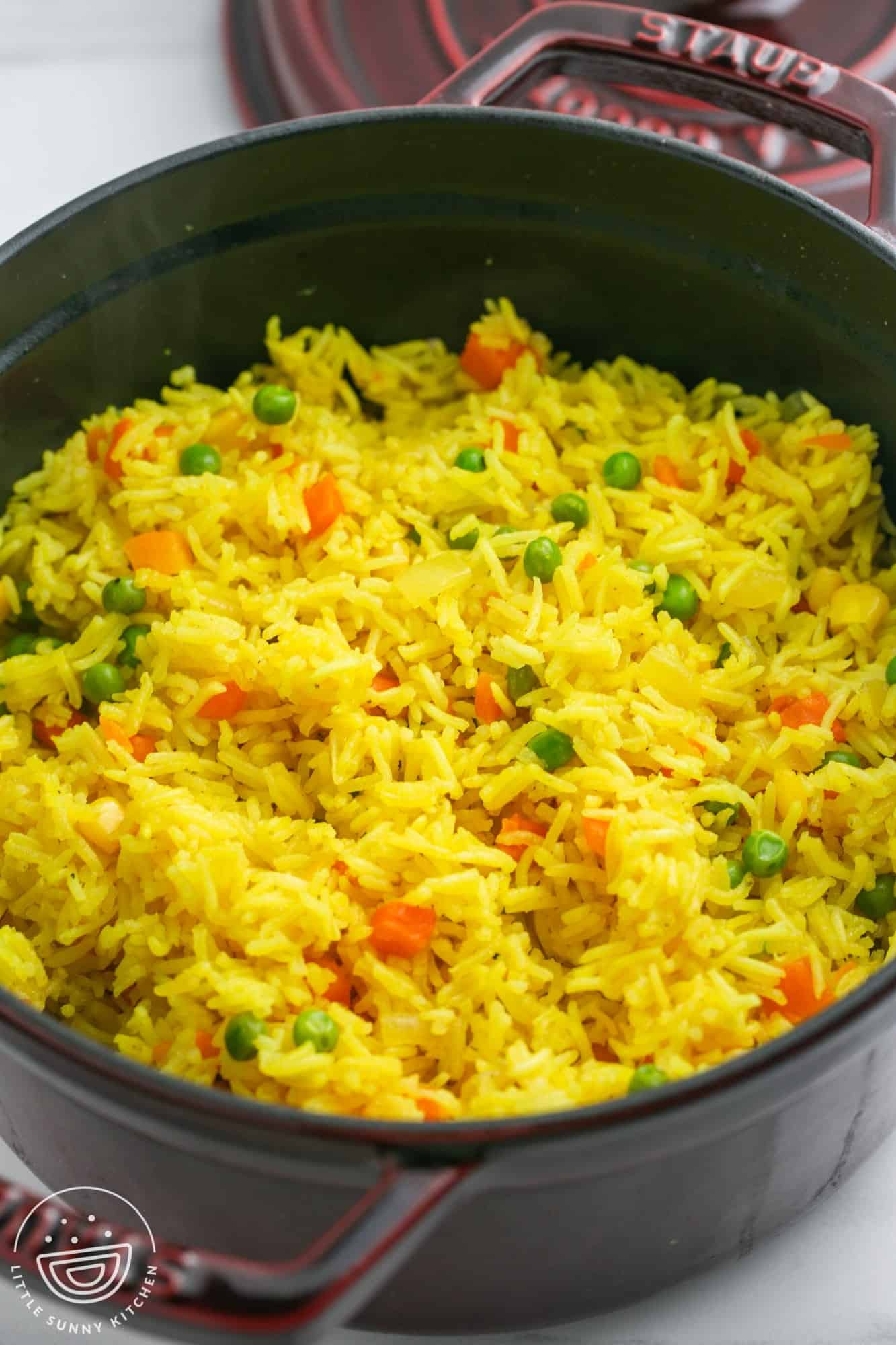 a large saucepan of yellow rice with vegetables.