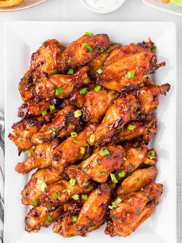 a rectangular white platter holding slow cooker chicken wings with bbq sauce.