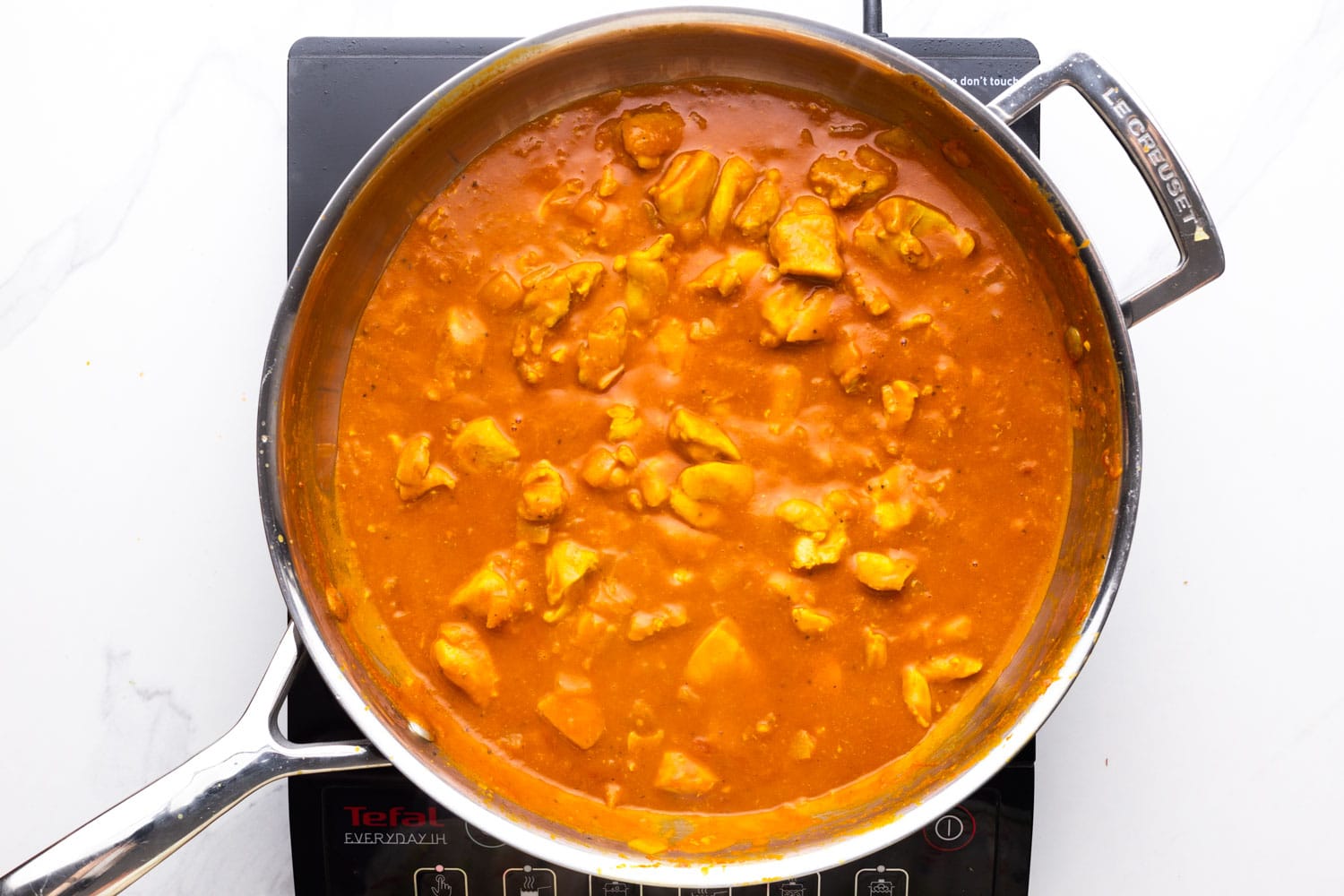 coconut chicken curry in a pan, simmered and thickened.
