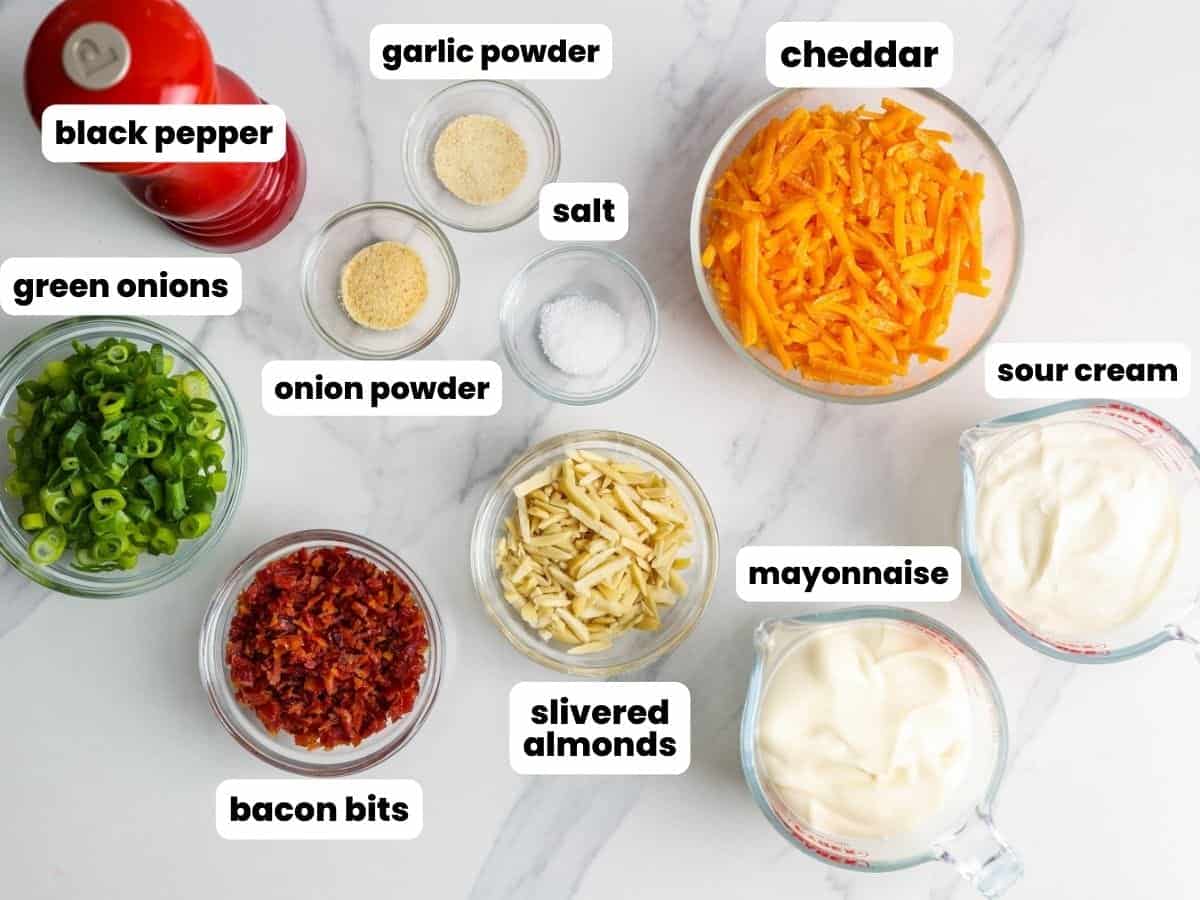 the ingredients for million dollar dips all in separate bowls on a marble counter. 