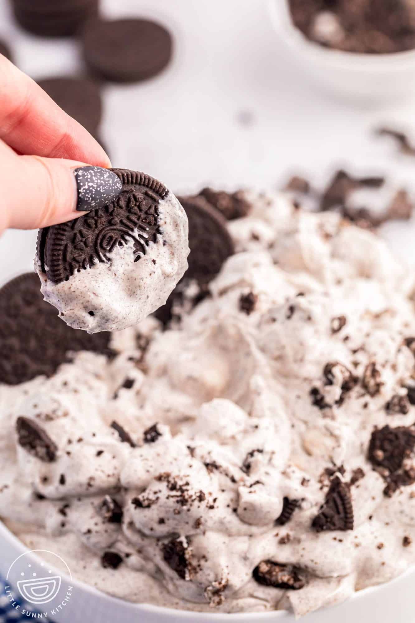 Dipping an oreo cookie in cookie fluff