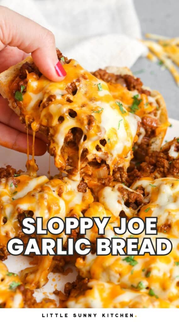 a hand holding a slice of cheesy meaty garlic bread. Text overlay says "sloppy joe garlic bread"