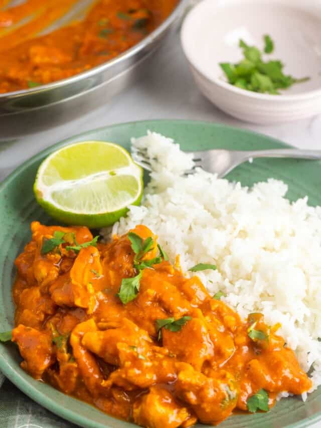 a green plate of coconut chicken curry with rice.