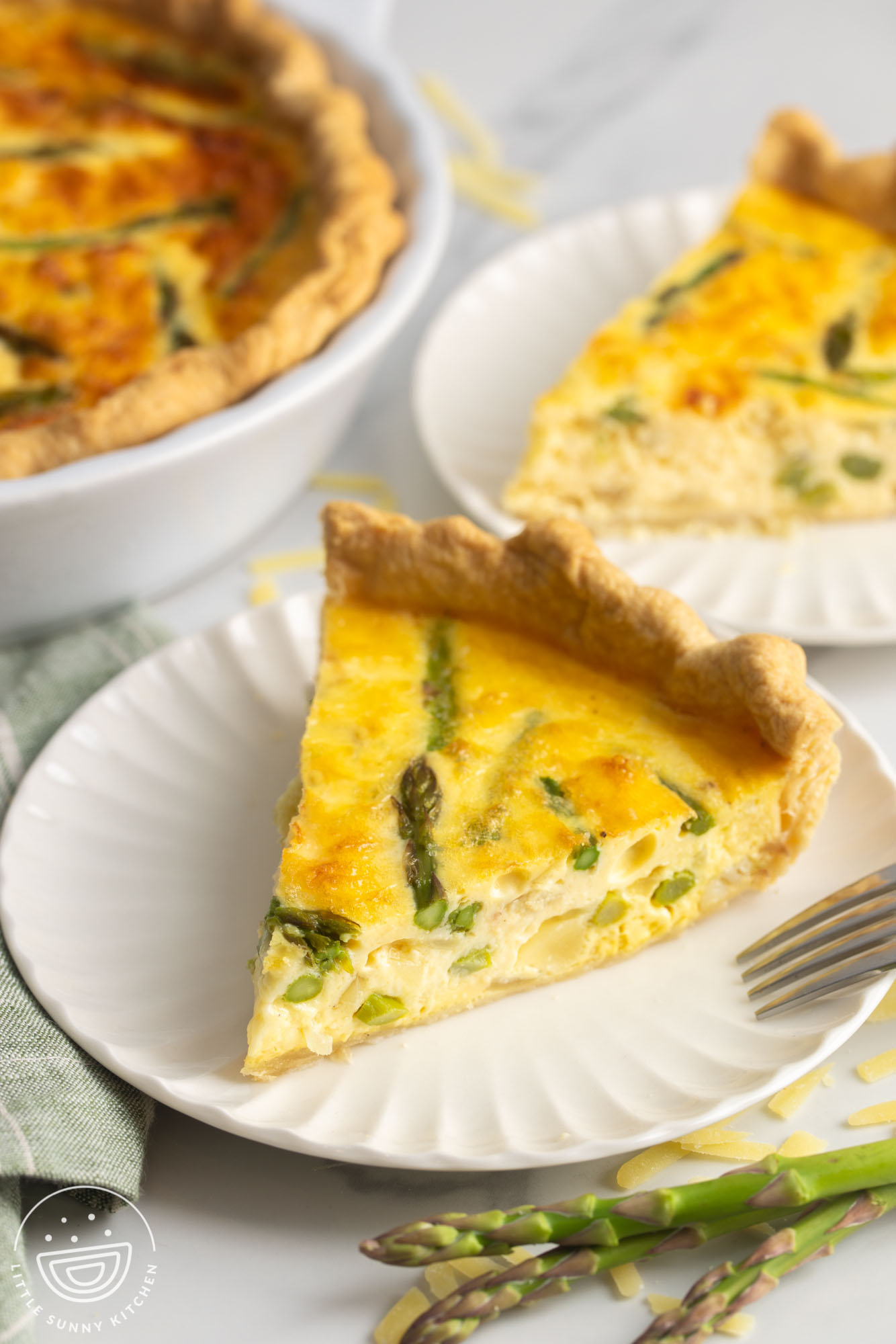 Two slices of asparagus quiche on small plates.