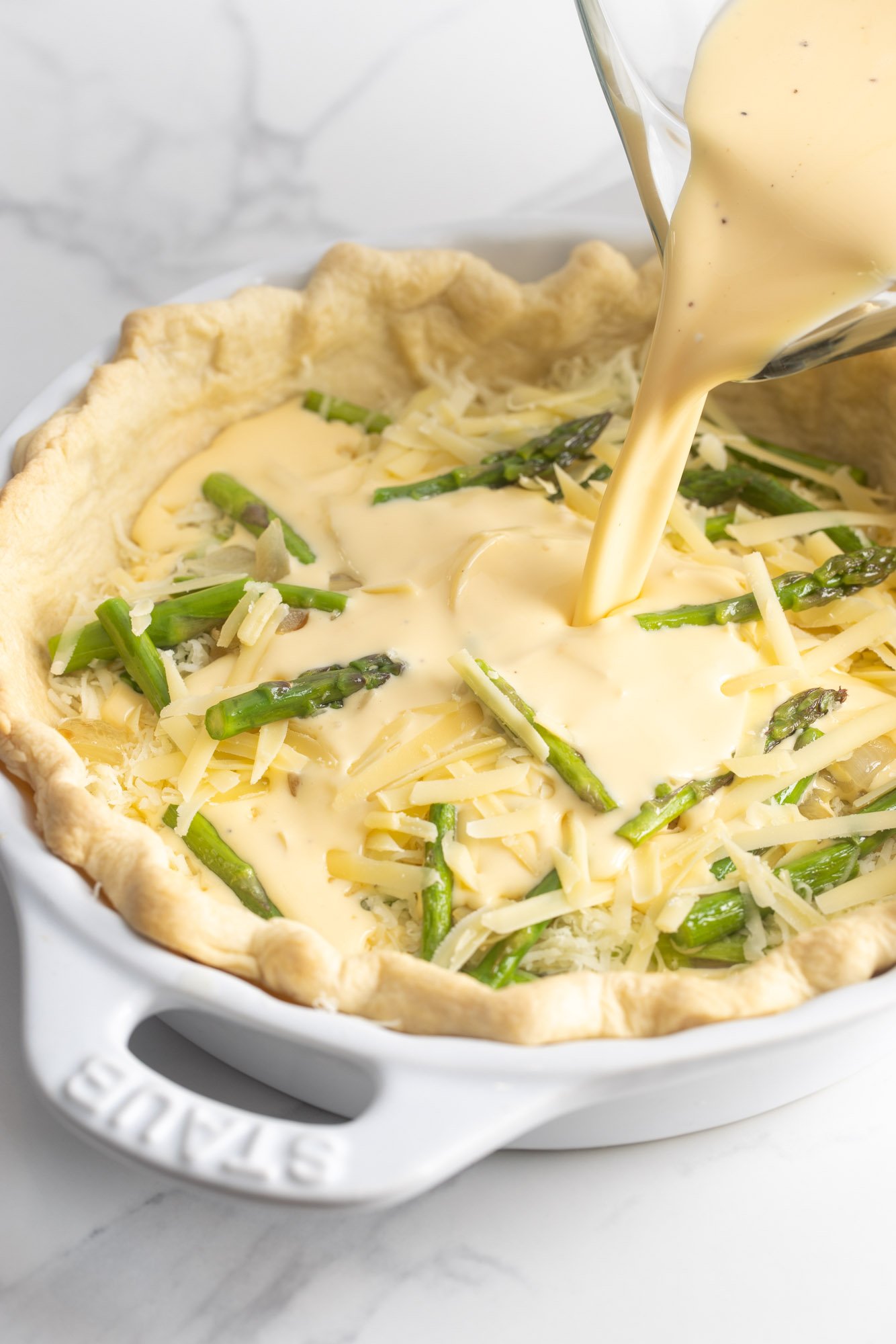 Egg mixture poured over asparagus and cheese in a baked quiche crust.