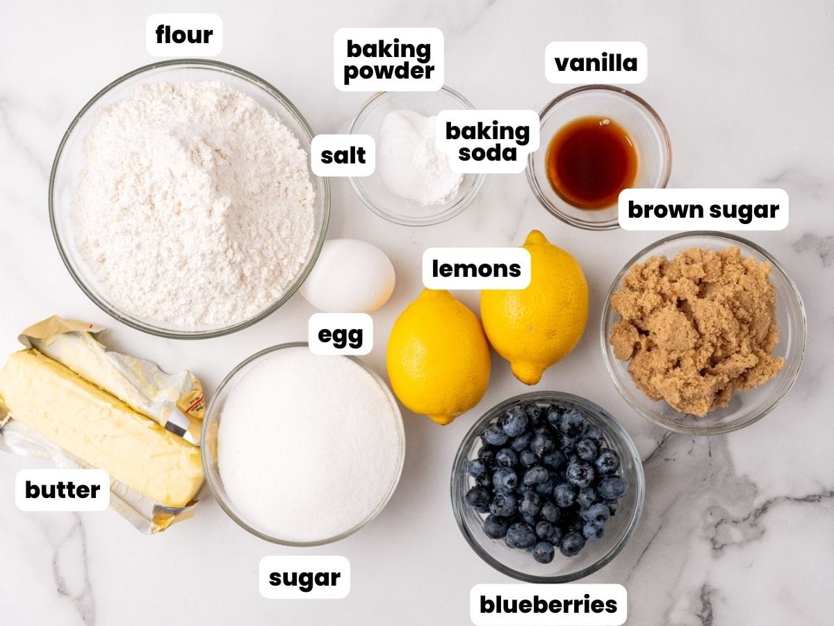 Ingredients for blueberry lemon cookies including butter, brown sugar, fresh berries, and vanilla extract.