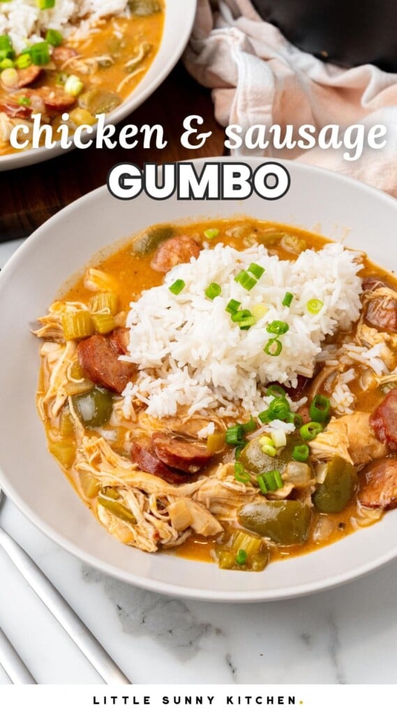 a deep plate holding a serving a chicken and sausage gumbo topped with white rice. Text overlay says "chicken and sausage gumbo"