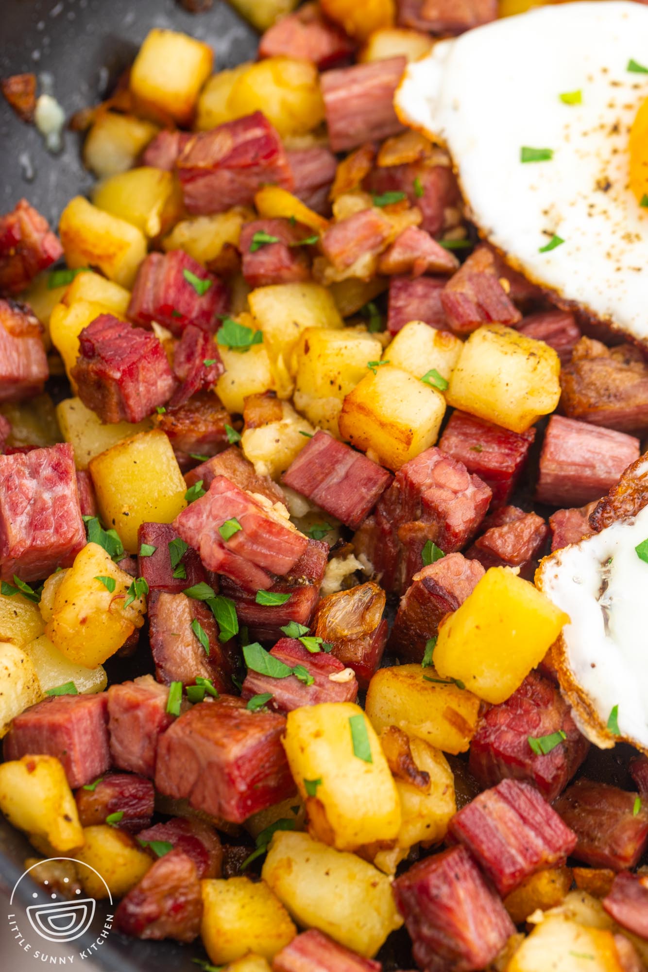closeup of hash made with cubes of corned beef and potatoes.