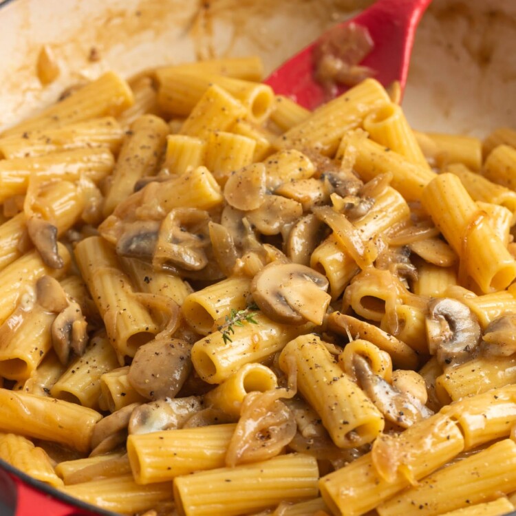 a red skillet filled with homemade french onion pasta.