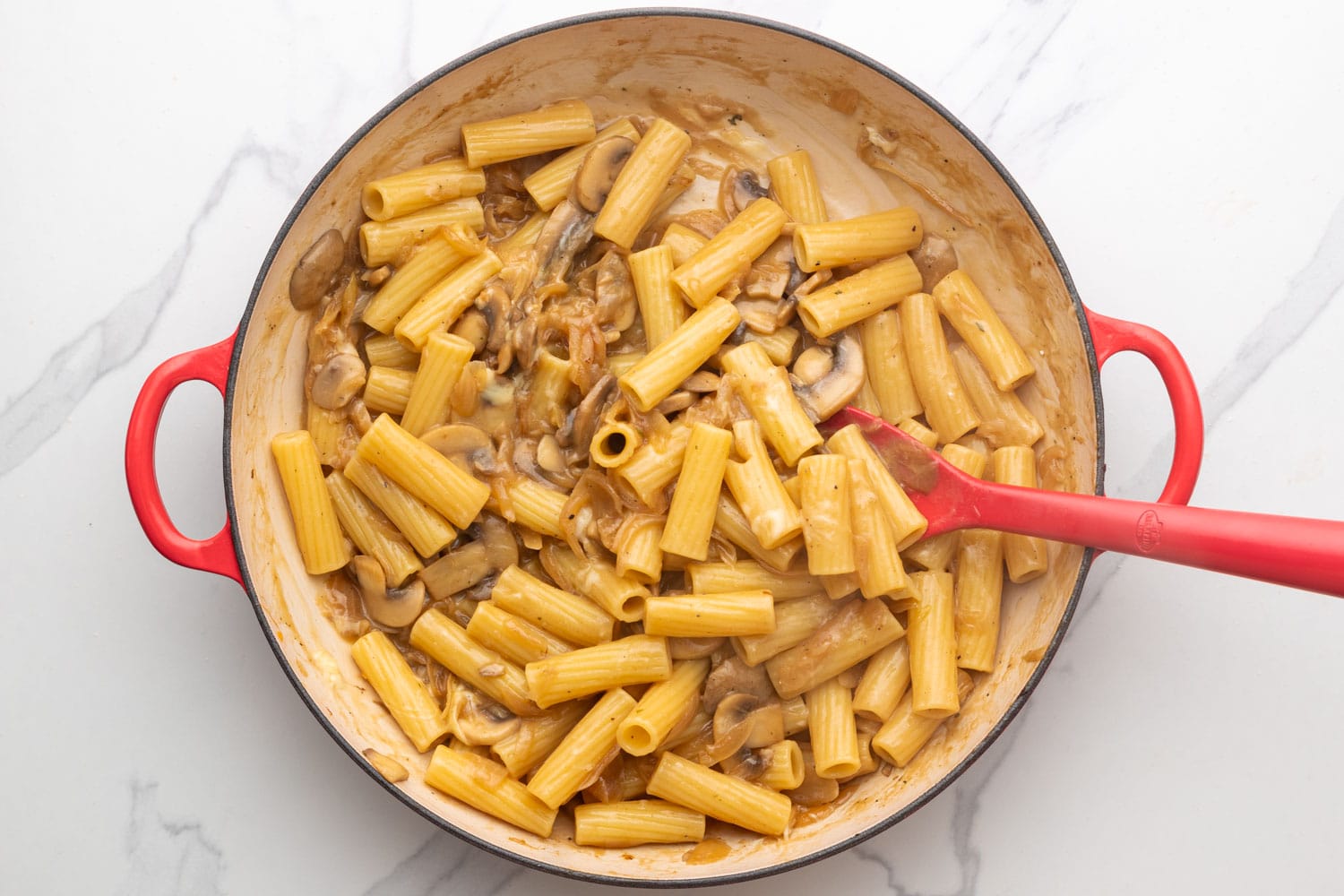 Cheese melted into rigatoni with onions and mushrooms.