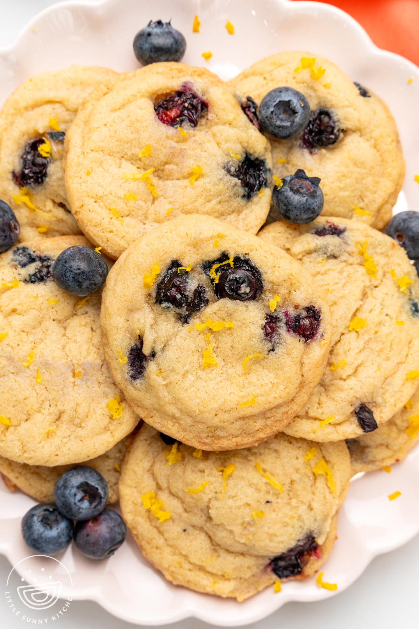 lemon blueberry cookies on a white ceramic plate.