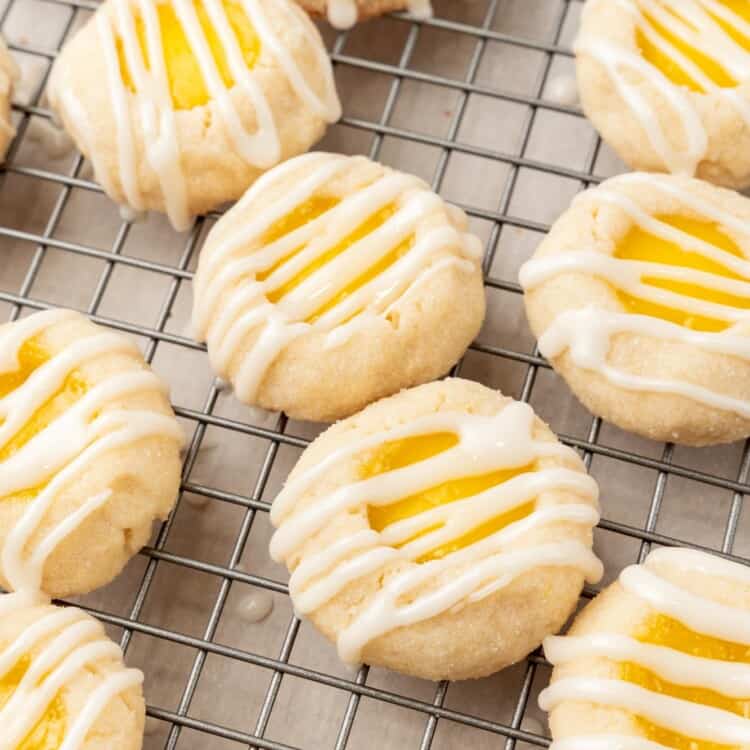 lemon cookies filled with lemon curd and topped with icing on a wire rack.