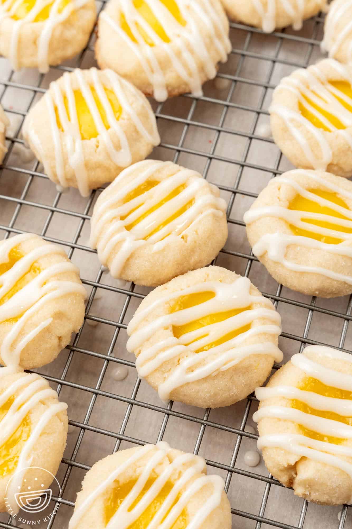 lemon cookies filled with lemon curd and topped with icing on a wire rack.