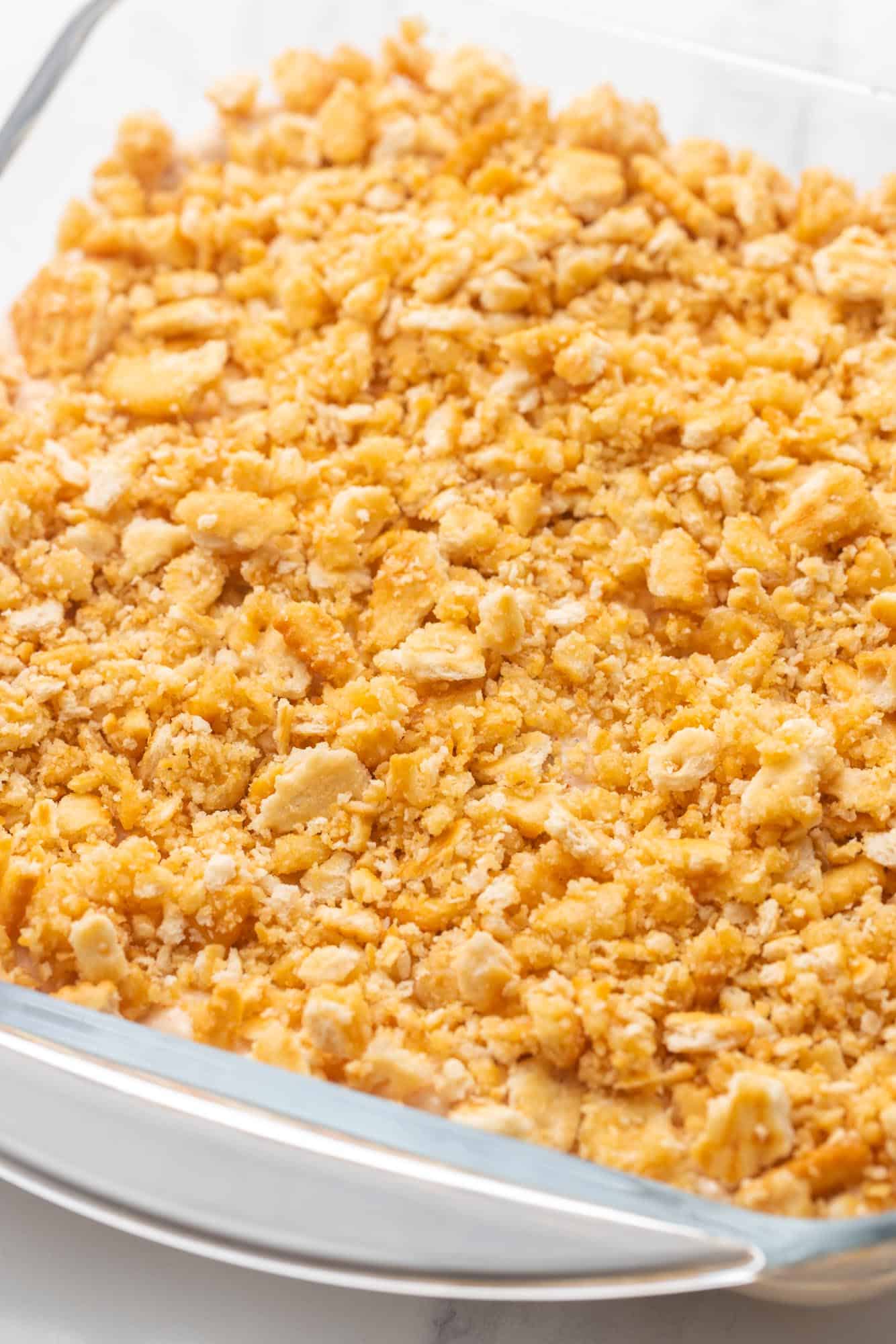 ritz cracker topped casserole in a glass square baking dish.