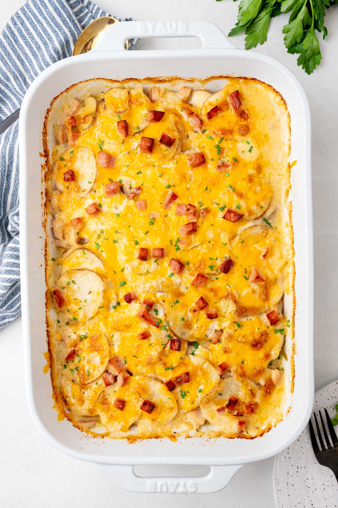 overhead view of a rectangular casserole dish of scalloped potatoes and ham.