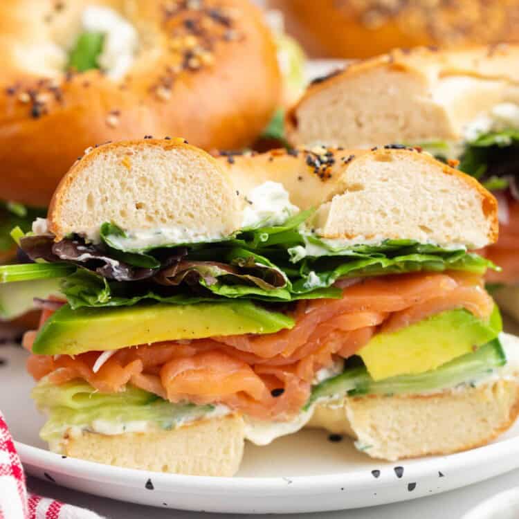 a smoked salmon bagel slice din half to show the layers of ingredients.