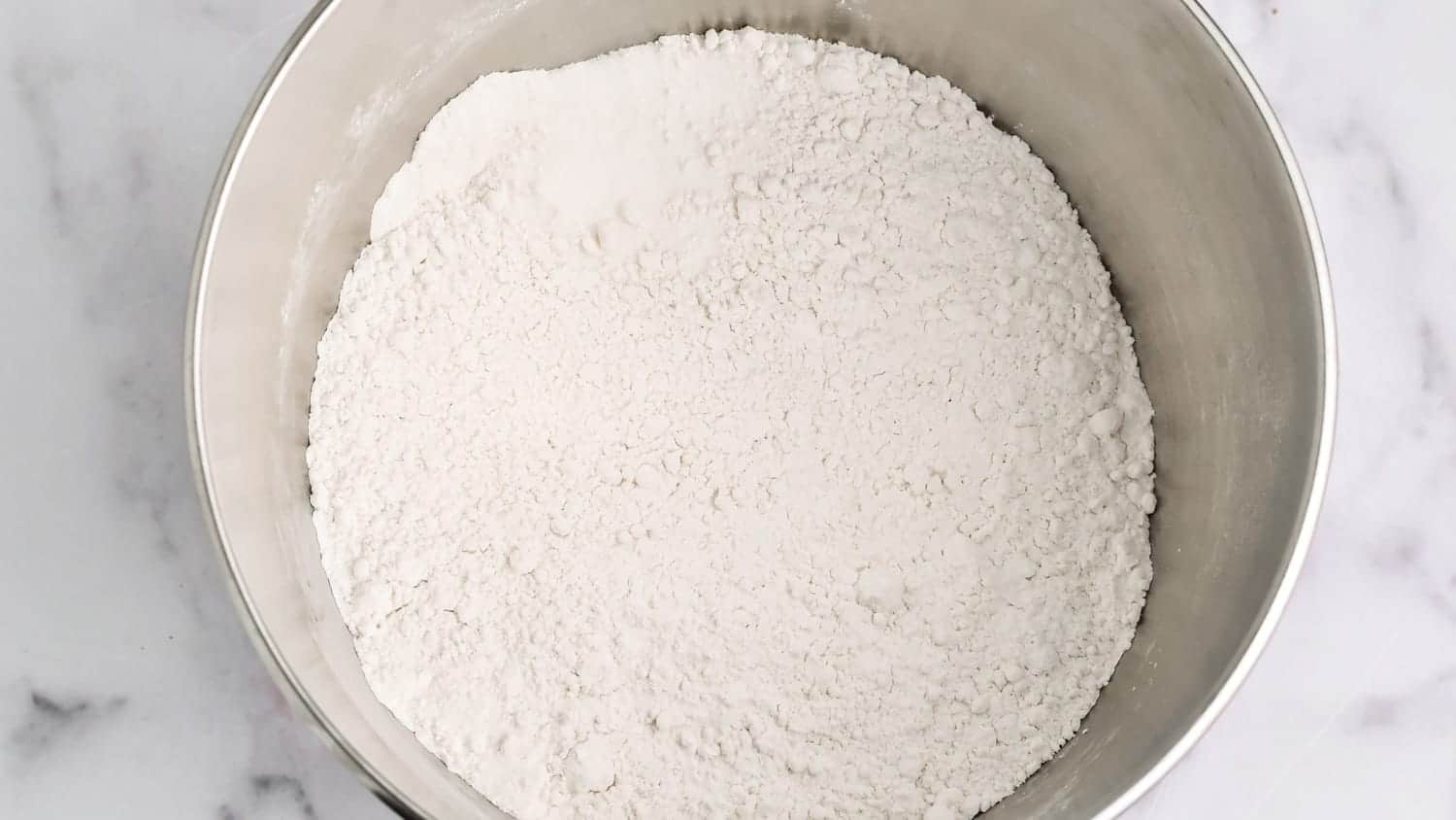 flour and dry ingredients in a metal mixing bowl
