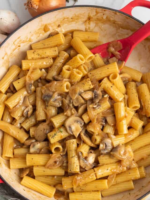 a skillet of french onion pasta - Rigatoni with a savory sauce made from caramelized onions and gruyere cheese.