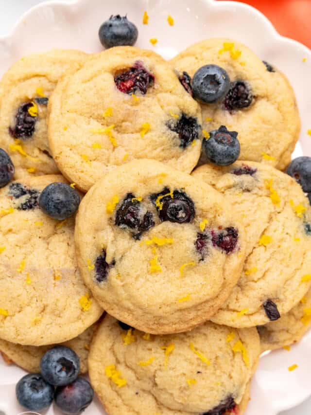 lemon blueberry cookies on a white ceramic plate.