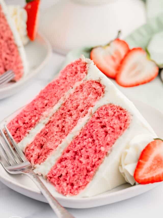 one large wedge slice of pink strawberry layer cake with cream cheese frosting. The cake is on a small dessert plate with a metal fork.