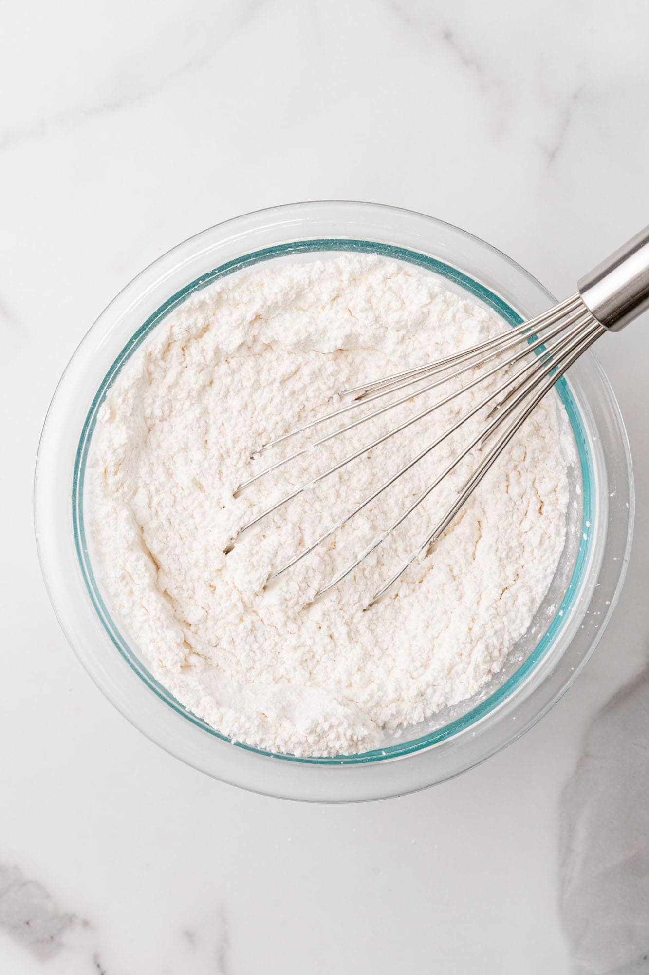 dry ingredients for cookie dough in a glass bowl with a whisk