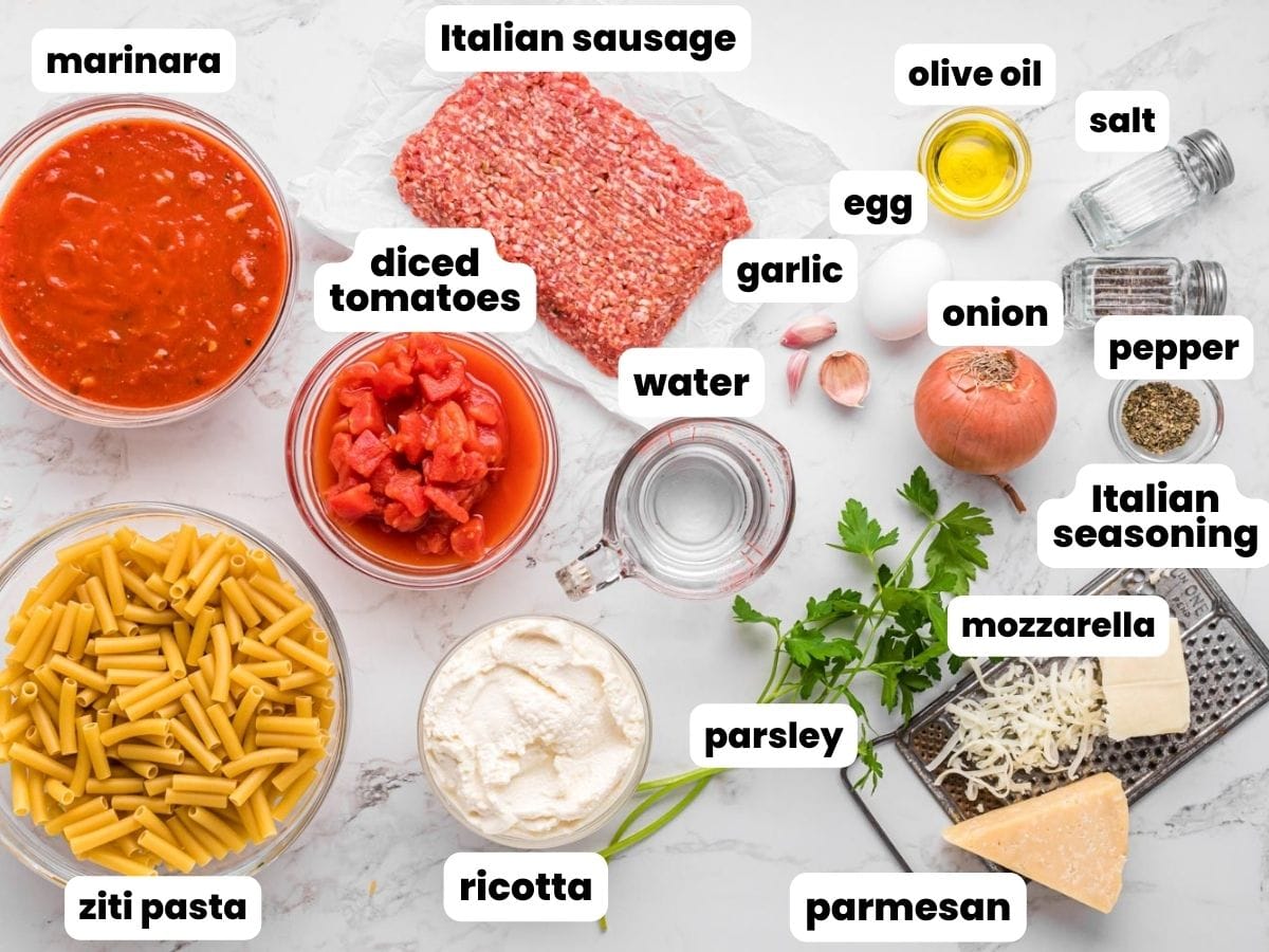 The ingredients needed to make baked zita with marinara, sausage, ricotta, and cheese.
