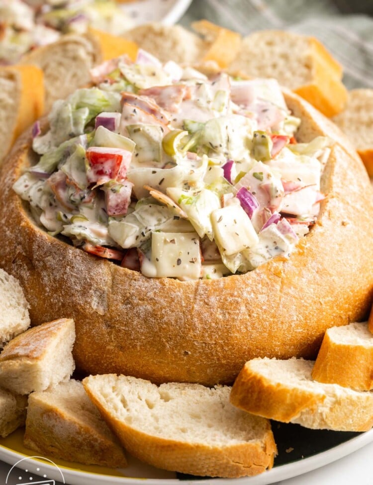 a platter of sliced bread. In the center is a large bread bowl filled with Italian Hoagie Dip.