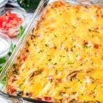 a glass casserole pan of cheesy king ranch chicken on a table.