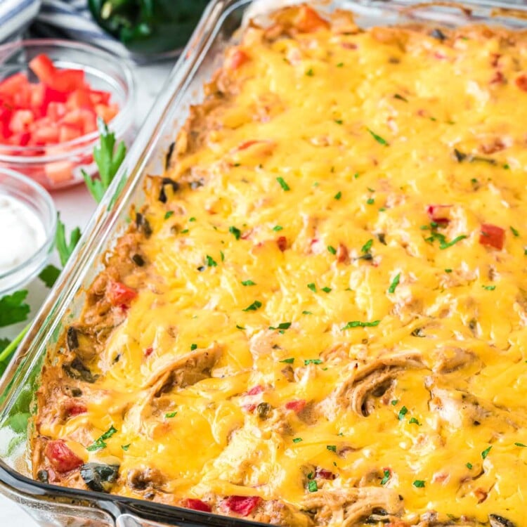 a glass casserole pan of cheesy king ranch chicken on a table.