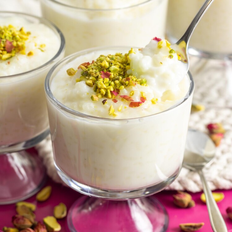Lebanese rice pudding served in transparent glass cups, topped with crushed pistachios.