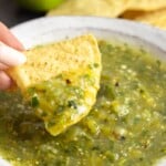 Dipping a tortilla chip in a bowl of salsa verde
