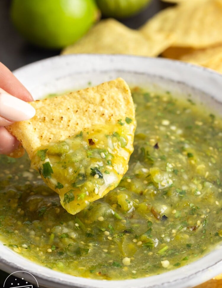 Dipping a tortilla chip in a bowl of salsa verde