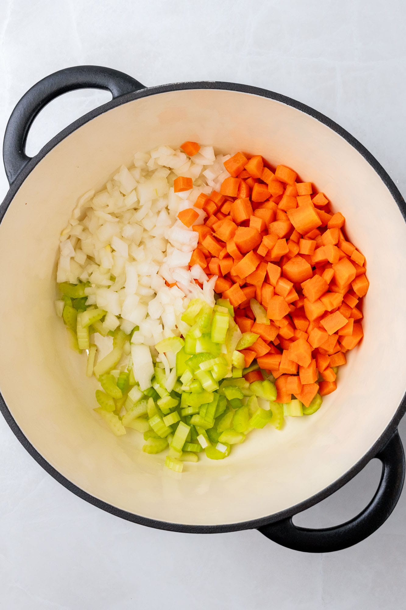 carrots, celery, onion, diced in the bottom of a dutch oven, viewed from overhead