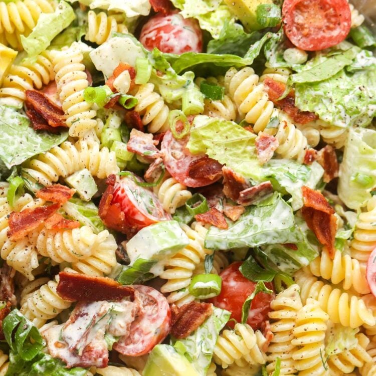 Closeup of a pasta salad with bacon, lettuce, and tomatoes dressed with Ranch