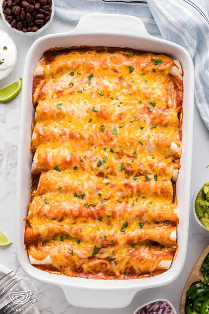 top down view of cheesy beef enchiladas in a casserole pan.